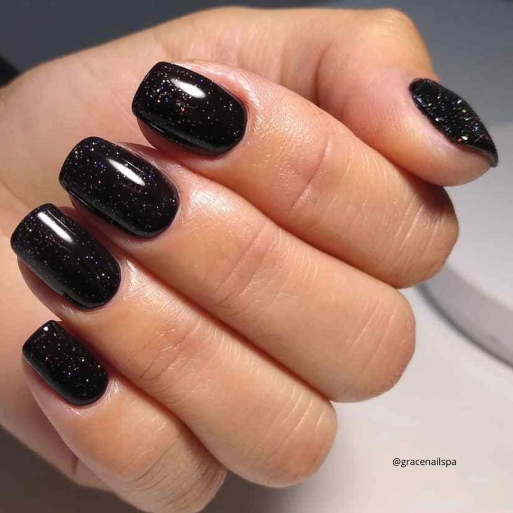 a hand with black nails with a starry night style
